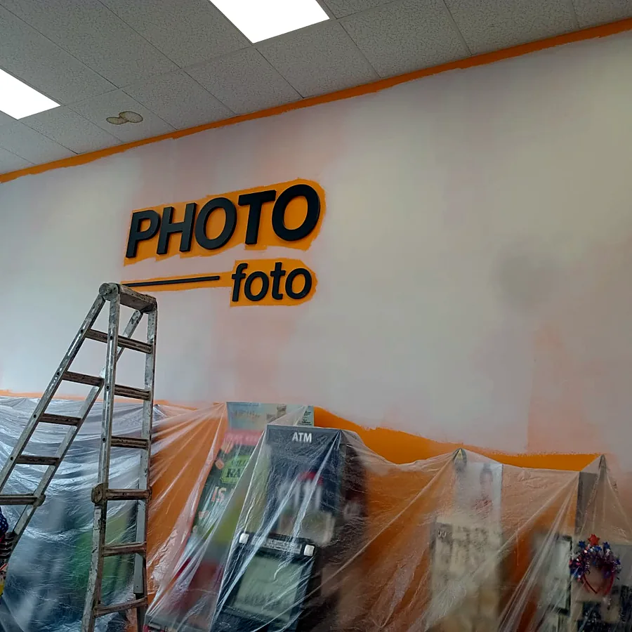Commercial interior repaint in progress with stock protected under plastic