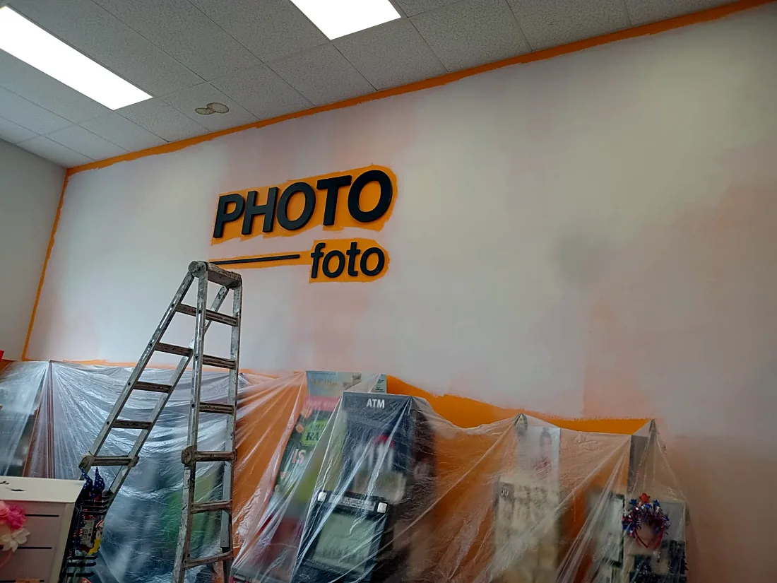 Commercial interior repaint in progress with stock protected under plastic